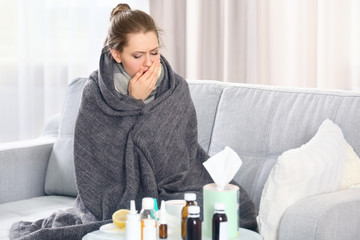 Ill girl covered in blanket on couch