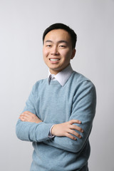 Handsome young Asian teacher on light background