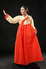 Beautiful young woman dressed in traditional clothing on black background