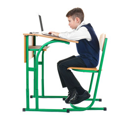 Incorrect posture concept. Schoolboy sitting at desk on white background