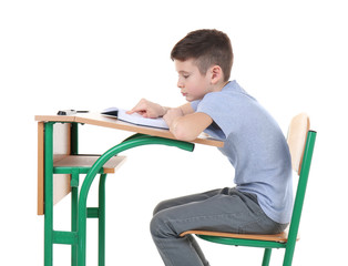 Incorrect posture concept. Schoolboy sitting at desk on white background