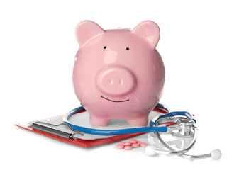 Piggy bank with stethoscope and clipboard on white background
