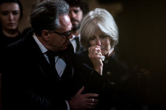 Senior woman being comforted at a funeral