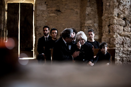 Senior woman being comforted at a funeral