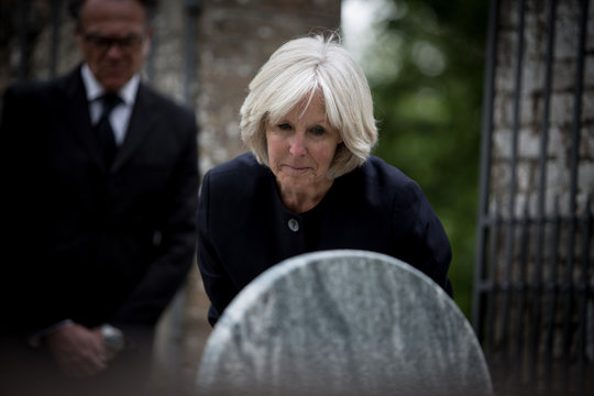 Senior woman reading a gravestone
