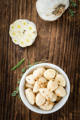 Garlic (preserved) on wooden background (selective focus)