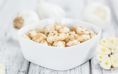 Garlic (preserved) on wooden background (selective focus)