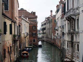 Fototapeta na wymiar A canal in venice with moored boats and old buildings