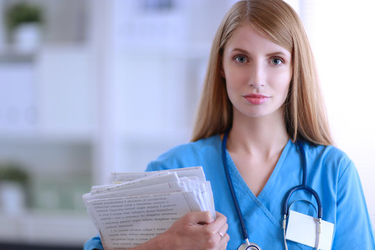 Doctor woman is standing in the near window