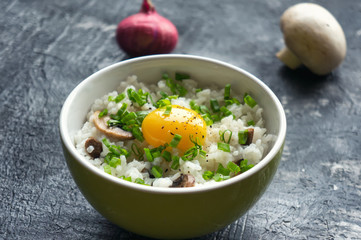 Traditional asian food (Tamago kake gohan) - hot white rice with mushrooms, raw yolk and green onion.