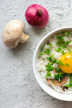 Tamago Kake Gohan. Healthy vegan food. Boiled white rice with raw yolk, mushroom and green onion. Top view. Vertical photo