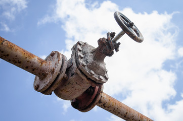 An old rusty gas control valve on the wall