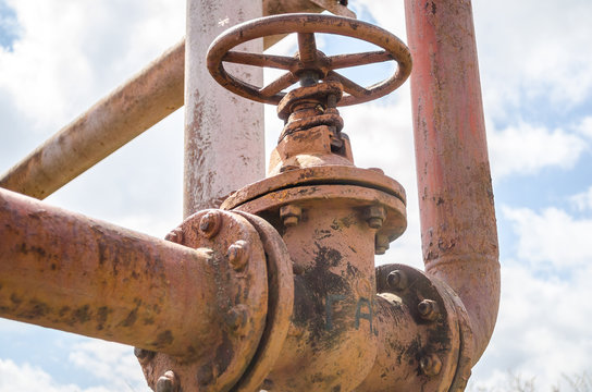 An old rusty gas control valve on the wall