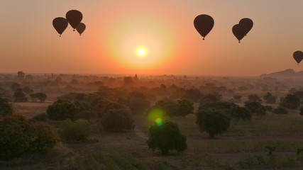 Hot air balloons over temple landscape at dawn in bagan, myanmar
