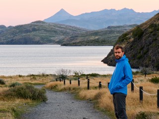 Fototapeta premium Man looking down gravel road to a lake