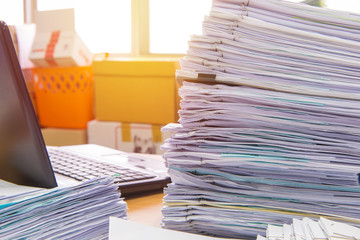documents on desk stack up high waiting to be managed