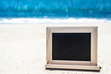 Black wood chalkboard on the sandy beach