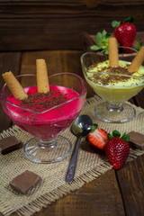 Puddings strawberry and vanilla in bowls on wooden background