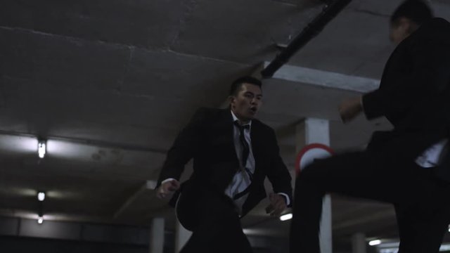  Asian gangster fighting in dark parking lot with members of a rival gang
