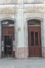 CIENFUEGOS, CUBA - DECEMBER 31, 2016:  Old house facade with people inside, street view