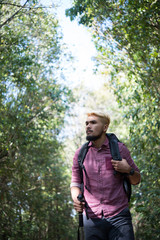 Adventure young man hiking in the mountains with a backpack.