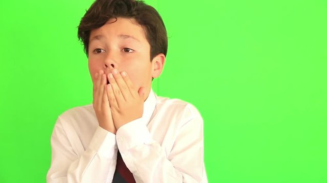 Portrait of a concerned scared child boy on chroma key green screen background