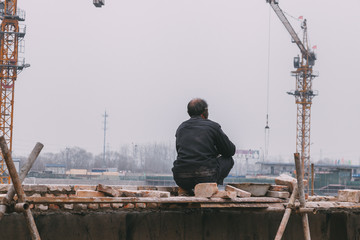 18 Dec,2014 Beijing. a men on a construction site in City with cranes ,takeing Bricks and.building...