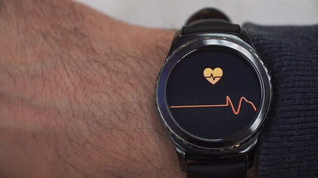 Smartwatch showing the heart rate to the user. The watch is on his right hand