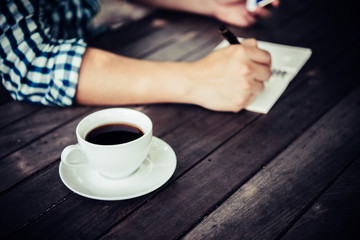 Close up of businessman using smartphone while working in the cafe.