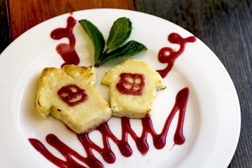 Delicious fresh cheese cake with strawberry jam for breakfast. Healthy eating in the morning in a cafe.