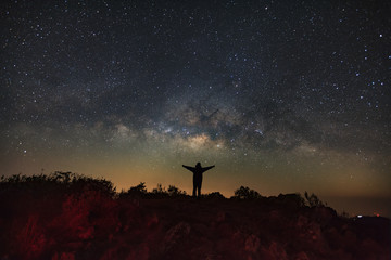 Landscape with milky way, Night sky with stars and silhouette of a standing man on Doi Luang Chiang Dao mountain, Long exposure photograph, with grain