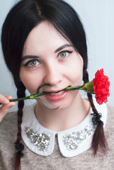 Playful girl holding a red carnation,