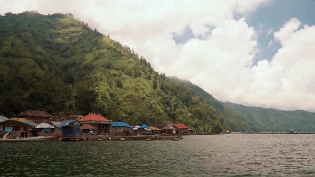 Traditional Trunyan village view from Lake Batur on cloudy summer day with some blue sky. Shot with Sony a7s in Bali, Indonesia
