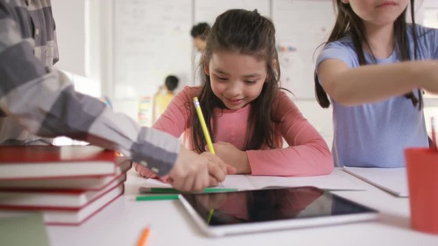  Portrait of happy little girl working at her desk in school classroom