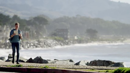 Young businessman walking along the amazing Pacific ocean coast - Powered by Adobe