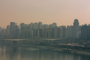 Fototapeta na wymiar Chongqing, China - Dec 22, 2015: The view of foggy crowded city bridges beside the jialing river