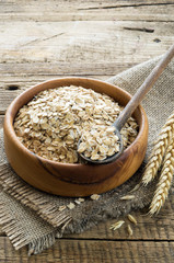 Oatmeal in the wooden plate on wooden background. Healthy Breakfast.