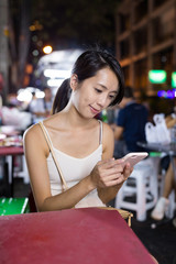 Woman using cellphone in night market