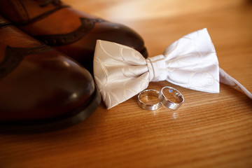 Wedding shoes, groom's bow tie and wedding rings with inscription ''Ipromise
