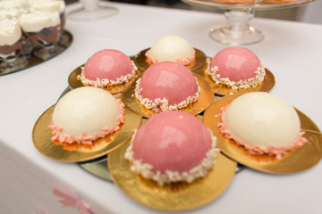 Colorful sweets on table. Pink cake and white cupcake