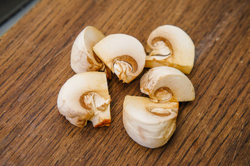 Cutting mushrooms on a wooden cutting board.