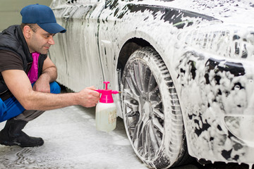 A man washes a black car
