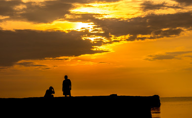 Silhouette of a man and women with sunset background.