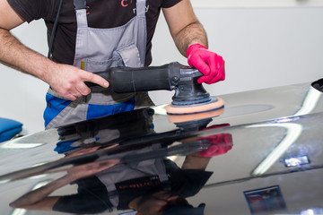 A man polishes a black car