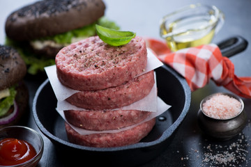 Frying pan with fresh uncooked beef burger cutlets, close-up, horizontal shot