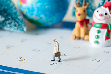 business miniature figures people walking on 31 day calendar and christmas ornamental background