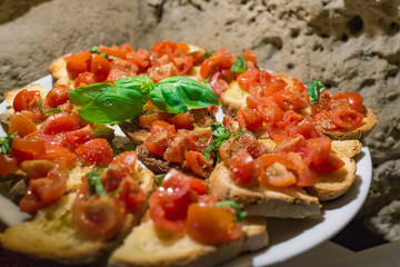 Italian bruschettas with chopped tomato and basil ready for breakfast
