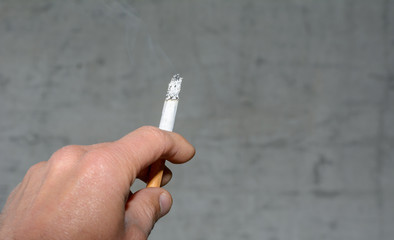 Zigarette zwischen den Fingern in der Hand