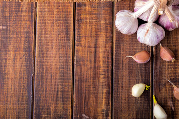 Garlic wrapped with twine on wooden background. Rustic.