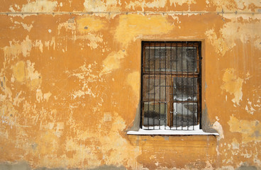 A barred window on the old wall
